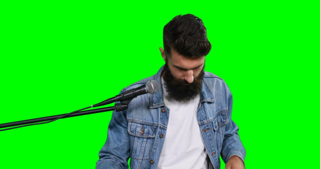 Bearded Man in Denim Jacket with Microphone on Green Screen - Free Images, Stock Photos and Pictures on Pikwizard.com