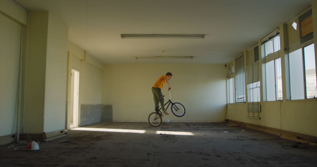 Young Man Performing Bicycle Stunts in Abandoned Building - Free Images, Stock Photos and Pictures on Pikwizard.com