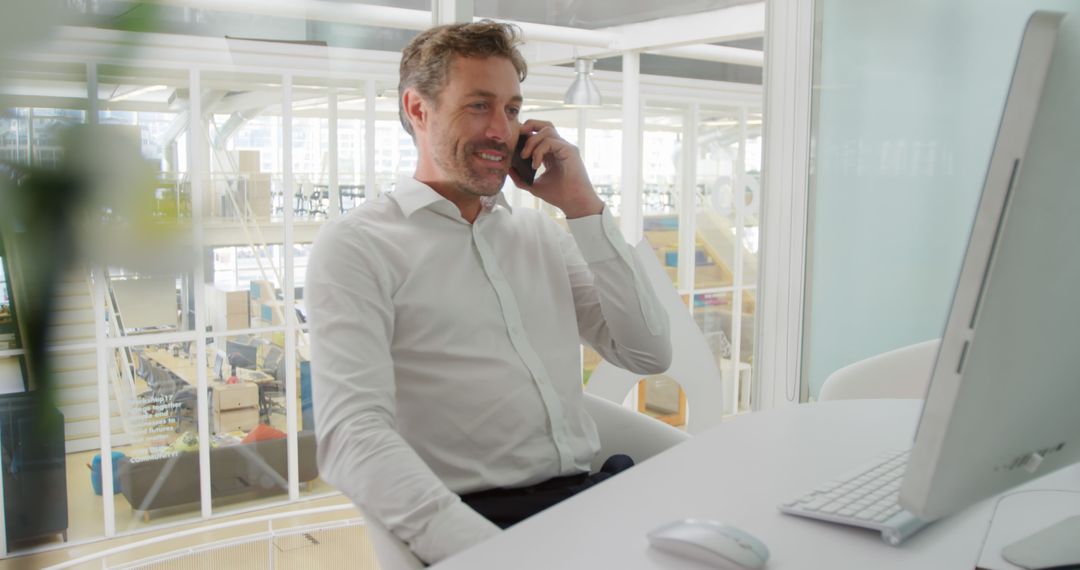 Businessman Talking on Phone at Modern Office Desk - Free Images, Stock Photos and Pictures on Pikwizard.com