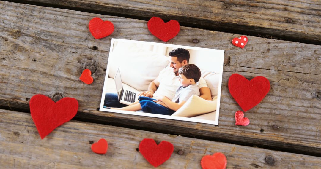 Father and Son Relaxing with Laptop on Wooden Table with Hearts - Free Images, Stock Photos and Pictures on Pikwizard.com