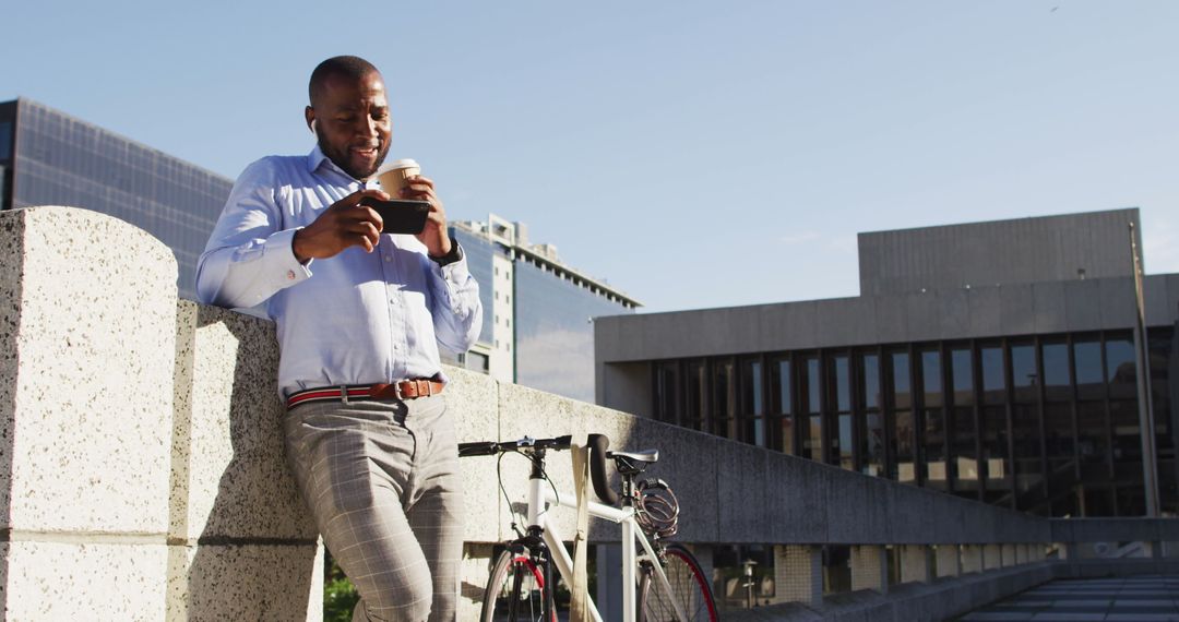 Man Enjoying Coffee and Smartphone Break by Bicycle in Urban Setting