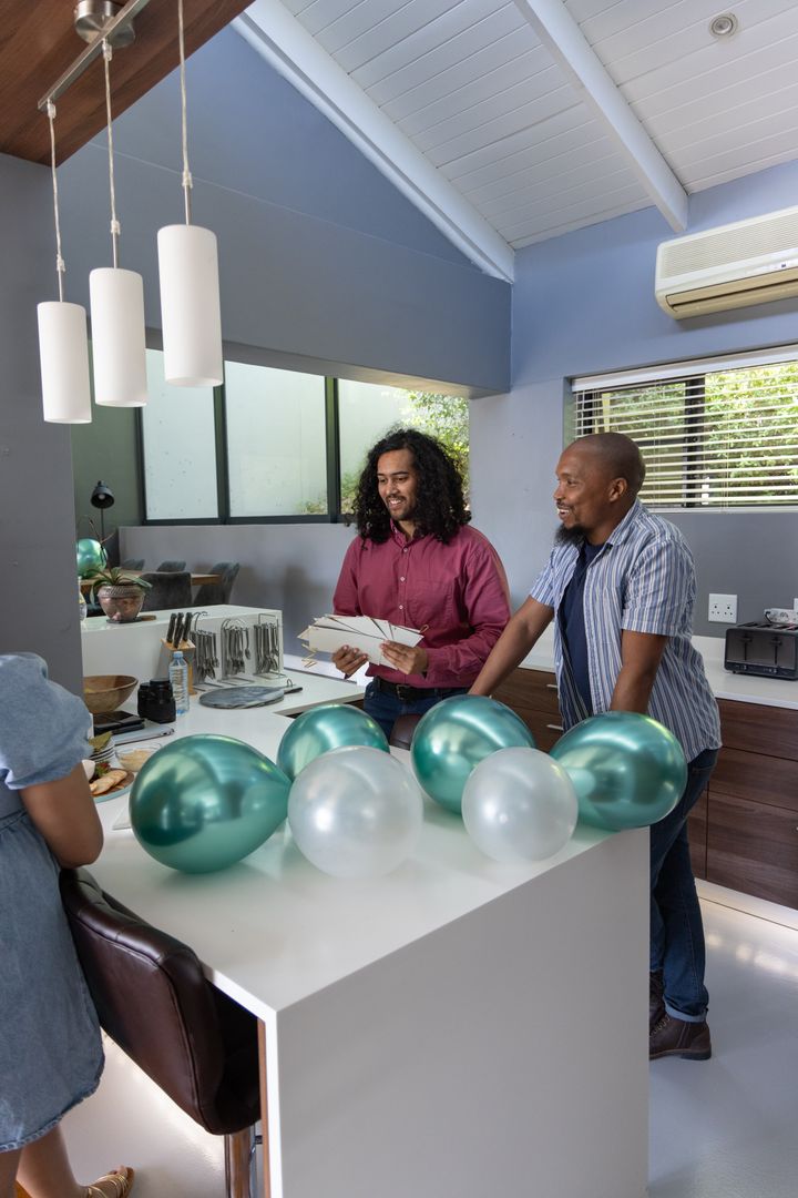 Friends Preparing Celebration with Balloons and Invitations at Home