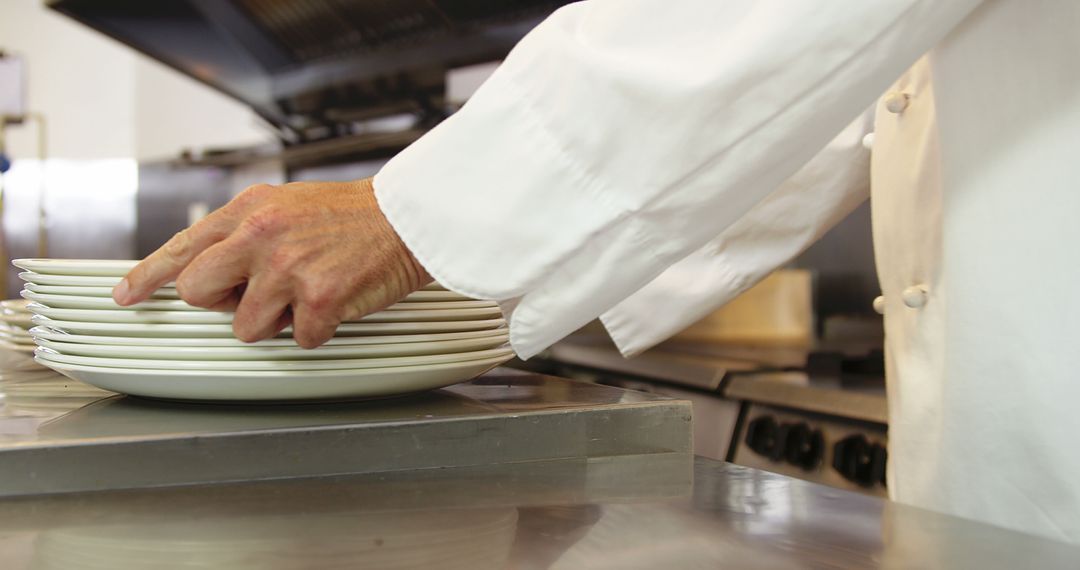 Chef Stacking White Plates in Commercial Kitchen - Free Images, Stock Photos and Pictures on Pikwizard.com