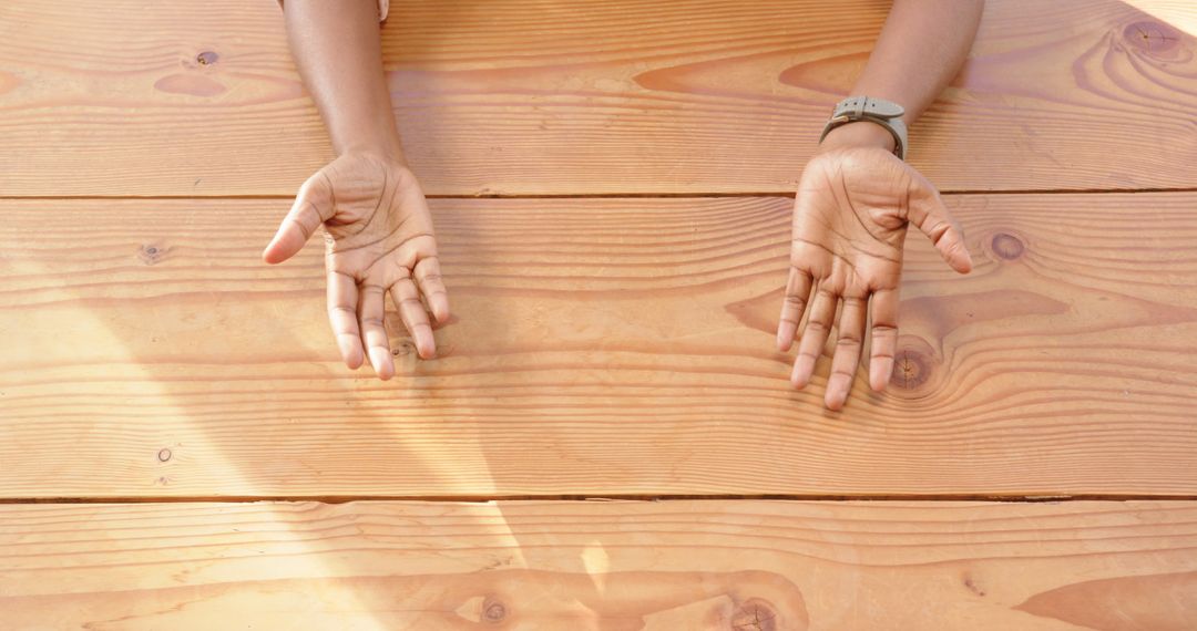 Open Hands Over Wooden Table Conveying Openness and Collaboration
