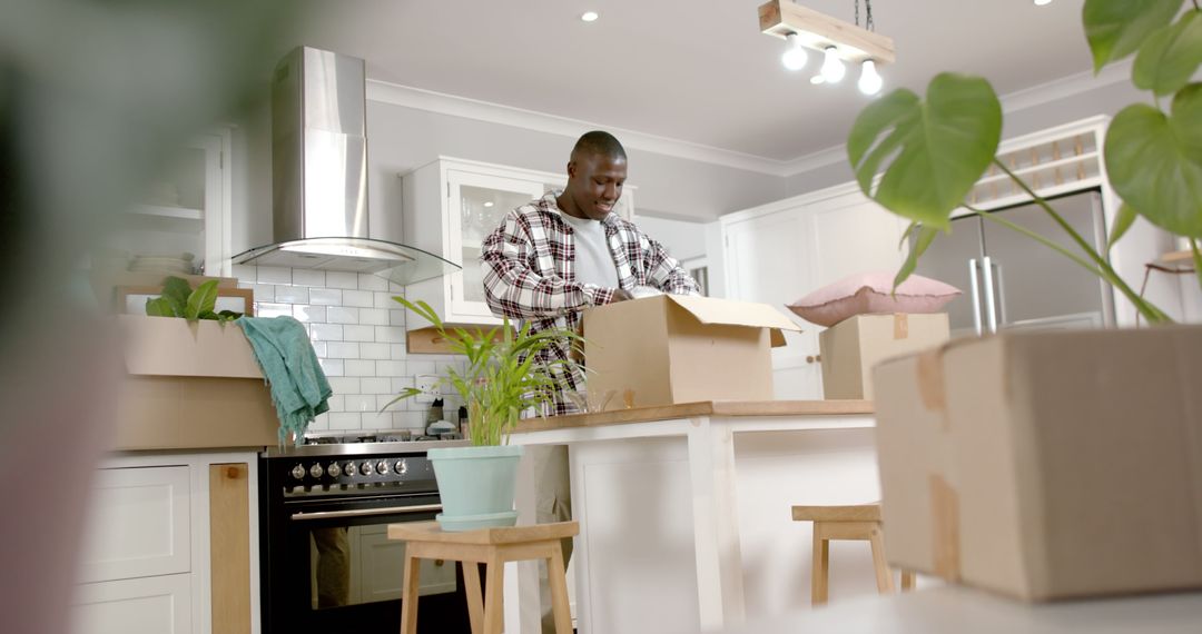 Young Man Unpacking Boxes in Modern Kitchen - Free Images, Stock Photos and Pictures on Pikwizard.com