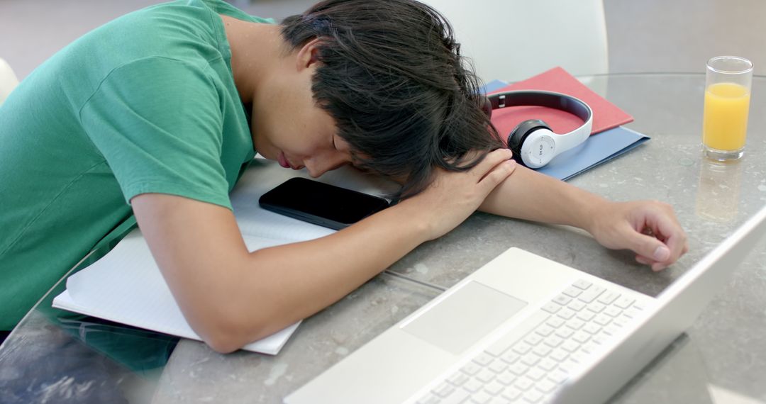Exhausted Student Sleeping by Open Laptop with Study Materials