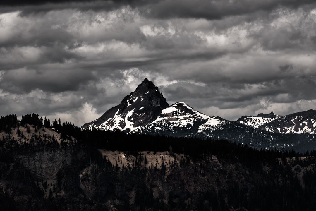 Dramatic Mountain Peak with Snow Under Stormy Skies - Free Images, Stock Photos and Pictures on Pikwizard.com