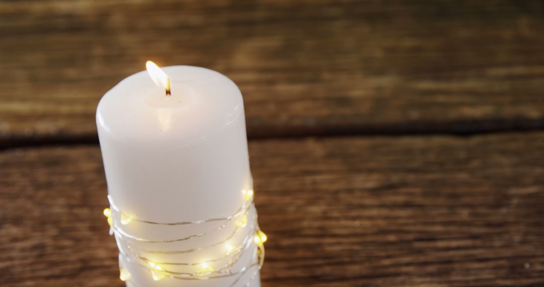 White Candle Wrapped with String Lights on Wooden Surface - Free Images, Stock Photos and Pictures on Pikwizard.com