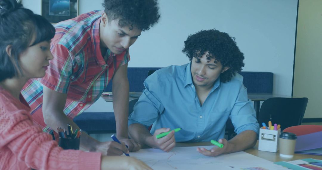 Students collaborating and brainstorming over table with highlighters, papers, coffee