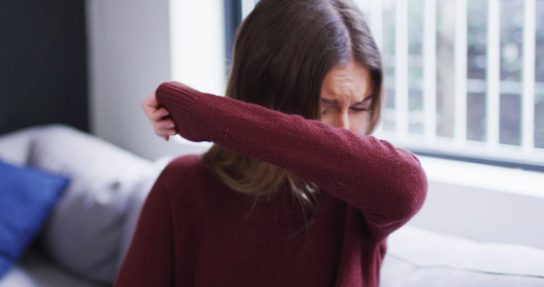 Woman Sneezing into Elbow in Home Environment - Free Images, Stock Photos and Pictures on Pikwizard.com