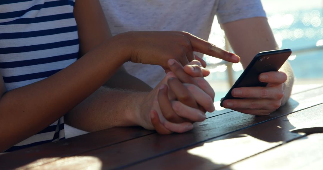 Couple Using Smartphone Outdoors Engaging in Discussion