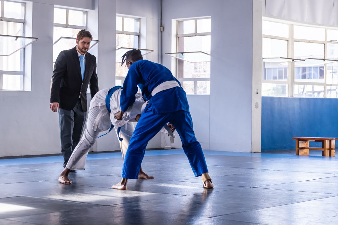 Mixed Martial Arts Grappling Match Supervised by Referee in Gym Setting
