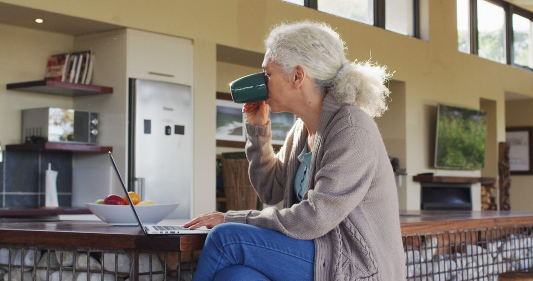 Senior Woman Drinking Coffee While Working on Laptop at Home - Free Images, Stock Photos and Pictures on Pikwizard.com