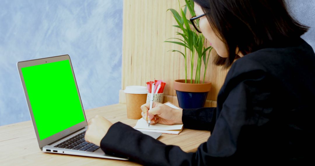 Businesswoman Working on Green Screen Laptop at Desk - Free Images, Stock Photos and Pictures on Pikwizard.com