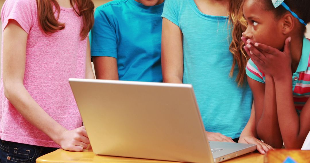 Diverse Children Collaborating on Laptop in Classroom