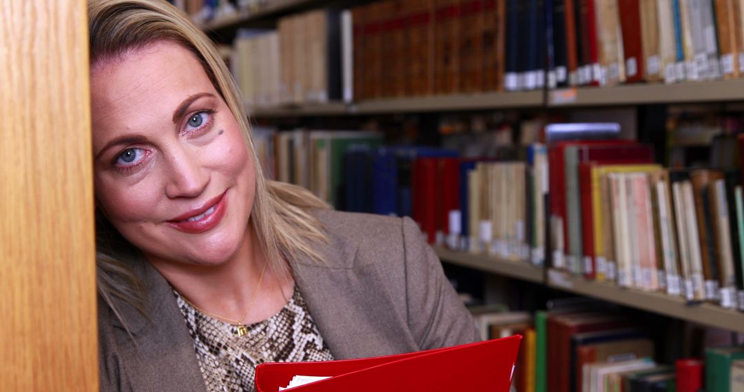 Smiling Woman Holding Binder in Library - Free Images, Stock Photos and Pictures on Pikwizard.com