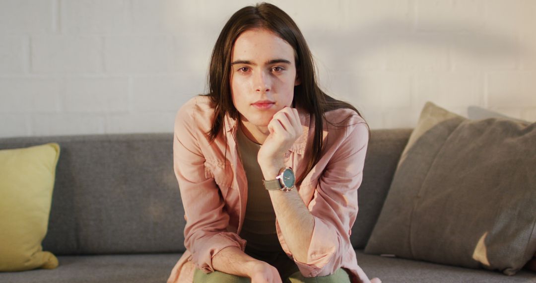 Portrait of caucasian non-binary transgender woman sitting on sofa, smiling - Free Images, Stock Photos and Pictures on Pikwizard.com