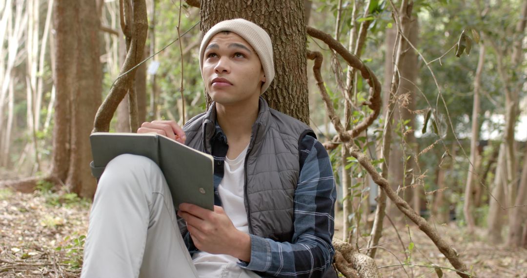 Young Man Sketching on Tablet in Forest