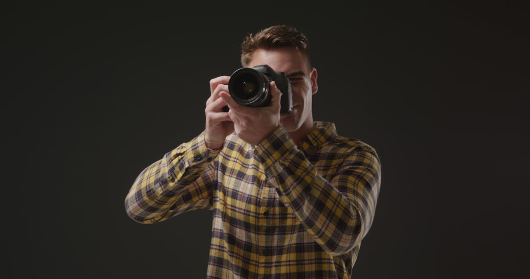 Photographer Holding Camera Against Dark Background - Free Images, Stock Photos and Pictures on Pikwizard.com