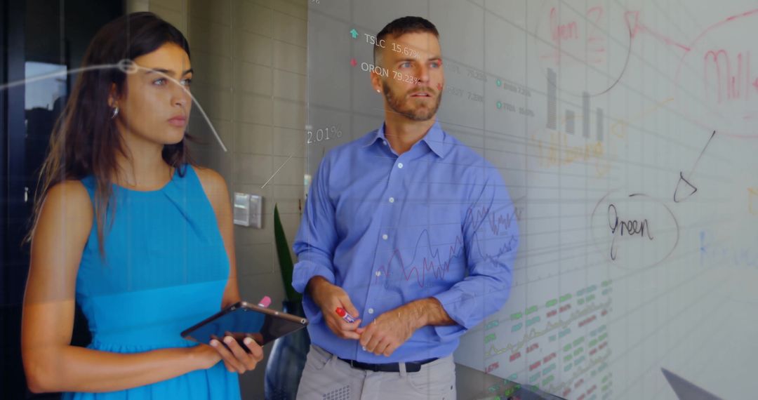 Colleagues Analyzing Financial Data on Office Whiteboard