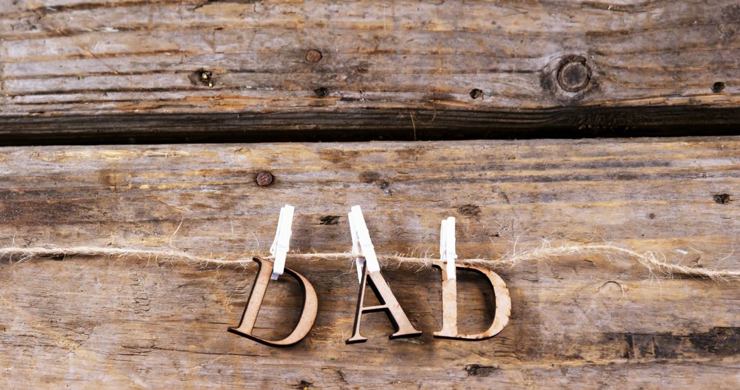 Rustic Letters Spelling 'Dad' Hanging on Wooden Background - Free Images, Stock Photos and Pictures on Pikwizard.com