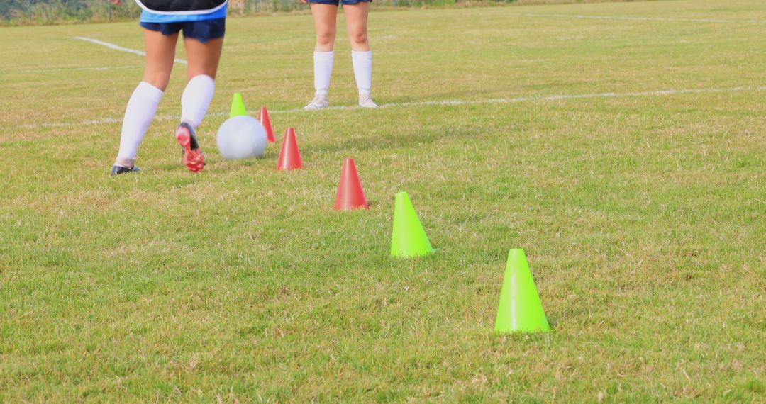 Girls Practicing Soccer on Green Field with Cones