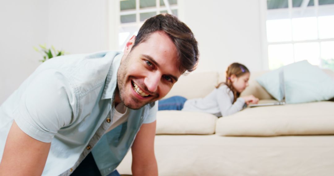 Man Smiling with Child Using Laptop on Sofa in Background - Free Images, Stock Photos and Pictures on Pikwizard.com