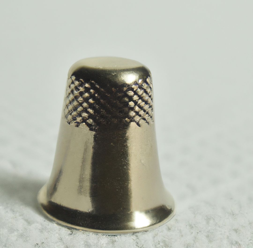 Image of close up of silver thimble on grey patterned fabric background - Free Images, Stock Photos and Pictures on Pikwizard.com