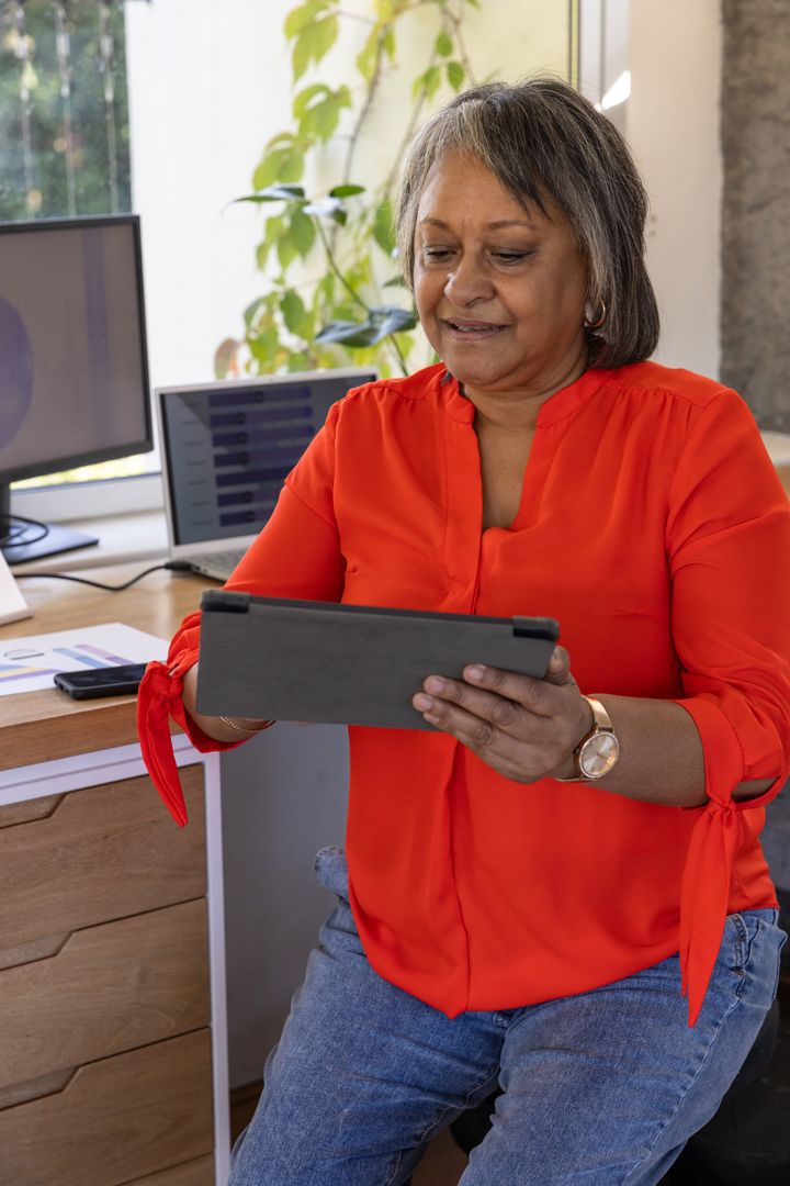 Senior Woman Using Tablet for Work in Modern Office Space