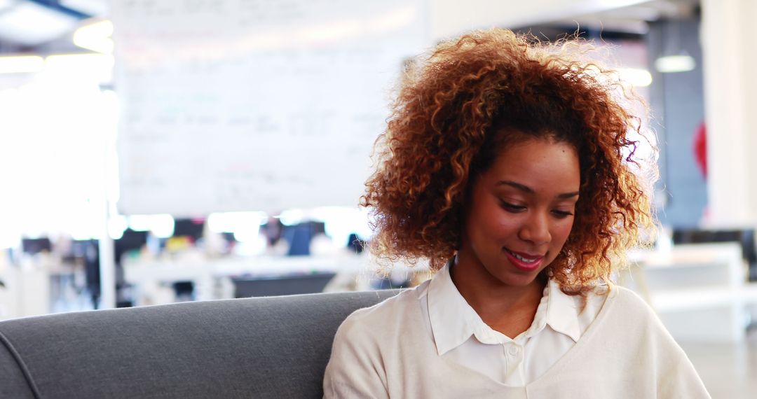 Smiling Businesswoman with Curly Hair in Modern Office Workspace
