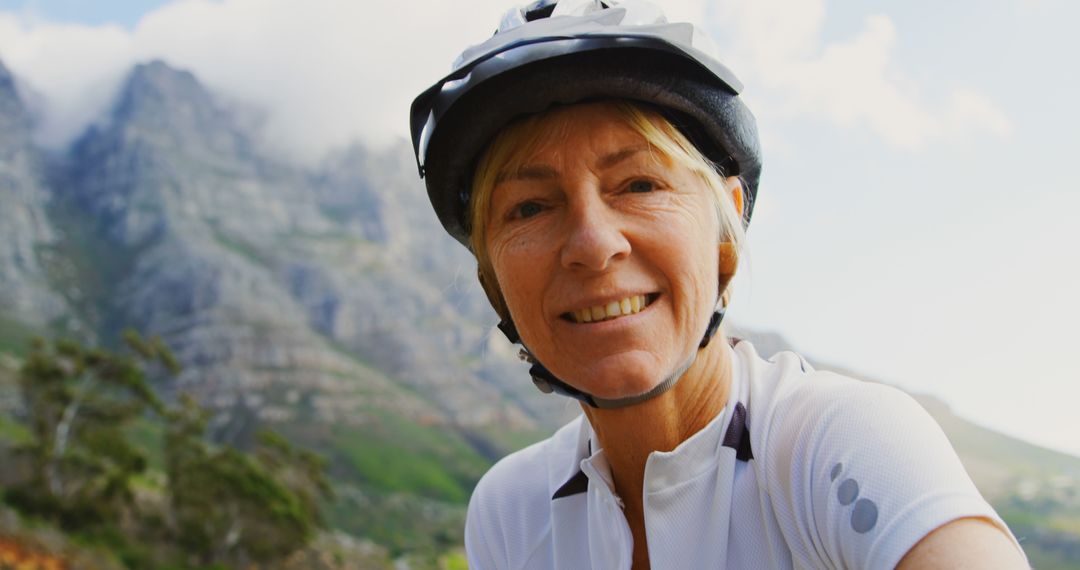 Senior Woman Cycling in Mountain Area Smiling at Camera - Free Images, Stock Photos and Pictures on Pikwizard.com