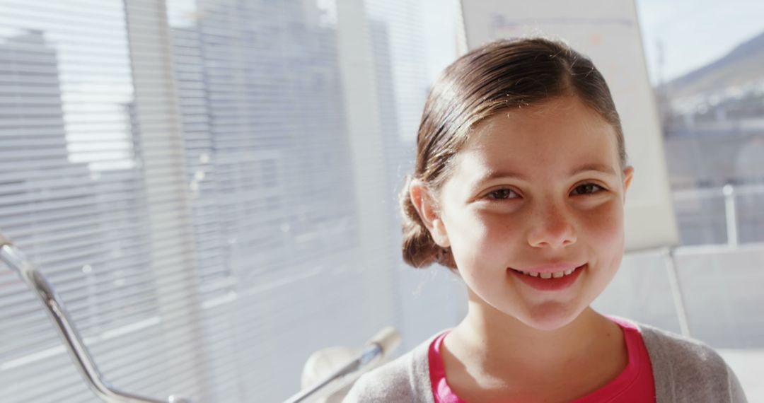 Smiling Girl in Bright Classroom by Window on Sunny Day - Free Images, Stock Photos and Pictures on Pikwizard.com