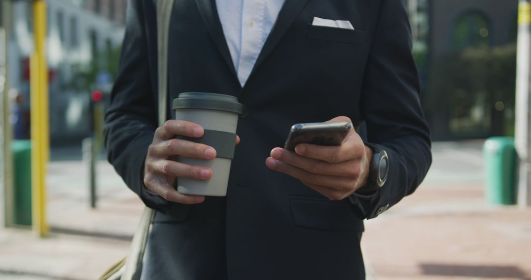 Business Professional Holding Coffee and Using Smartphone Outdoors - Free Images, Stock Photos and Pictures on Pikwizard.com