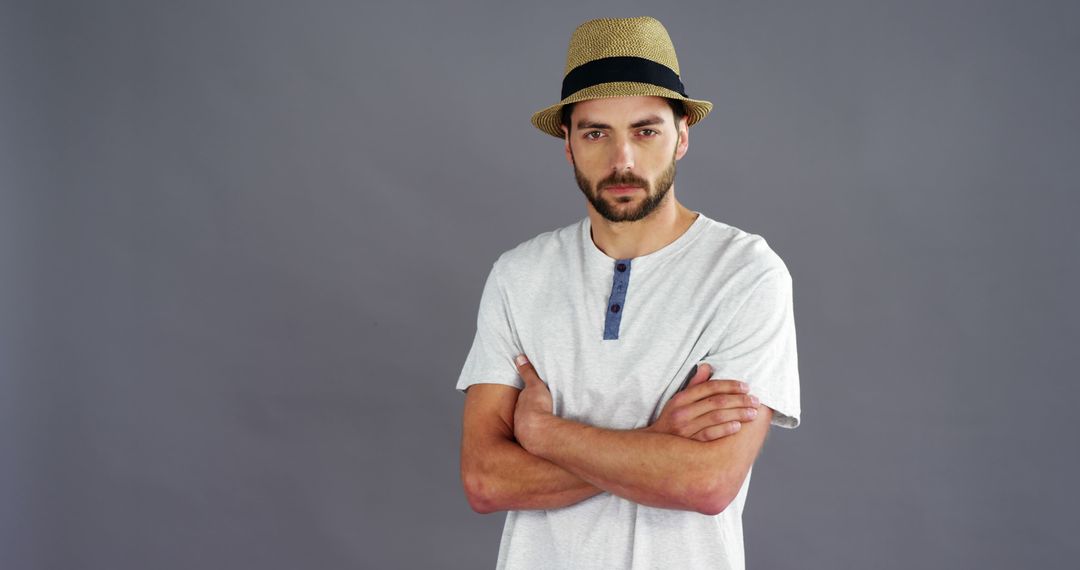 Confident Young Man Posing in Hat Against Gray Background - Free Images, Stock Photos and Pictures on Pikwizard.com