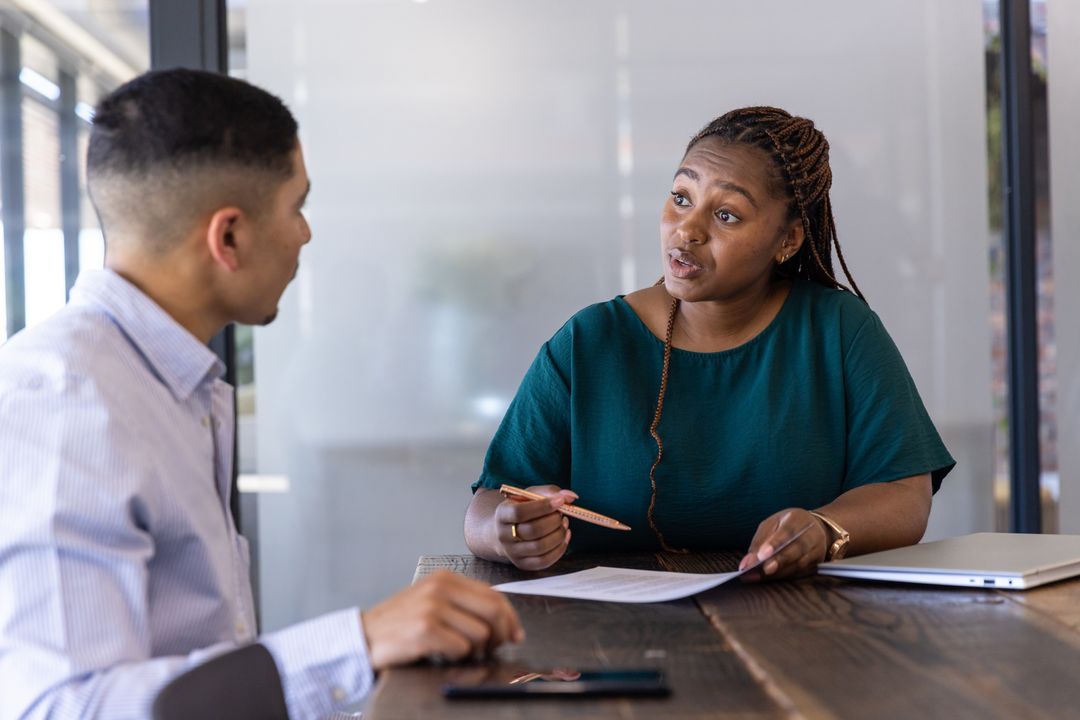 Office Colleagues Discussing Documents in Modern Meeting Room