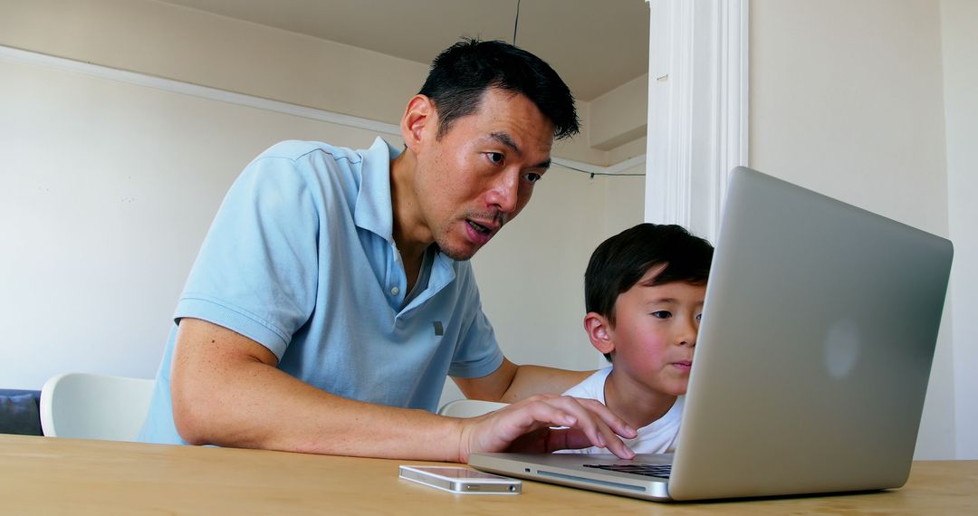 Father Helping Son with Online Homework on Laptop at Home - Free Images, Stock Photos and Pictures on Pikwizard.com