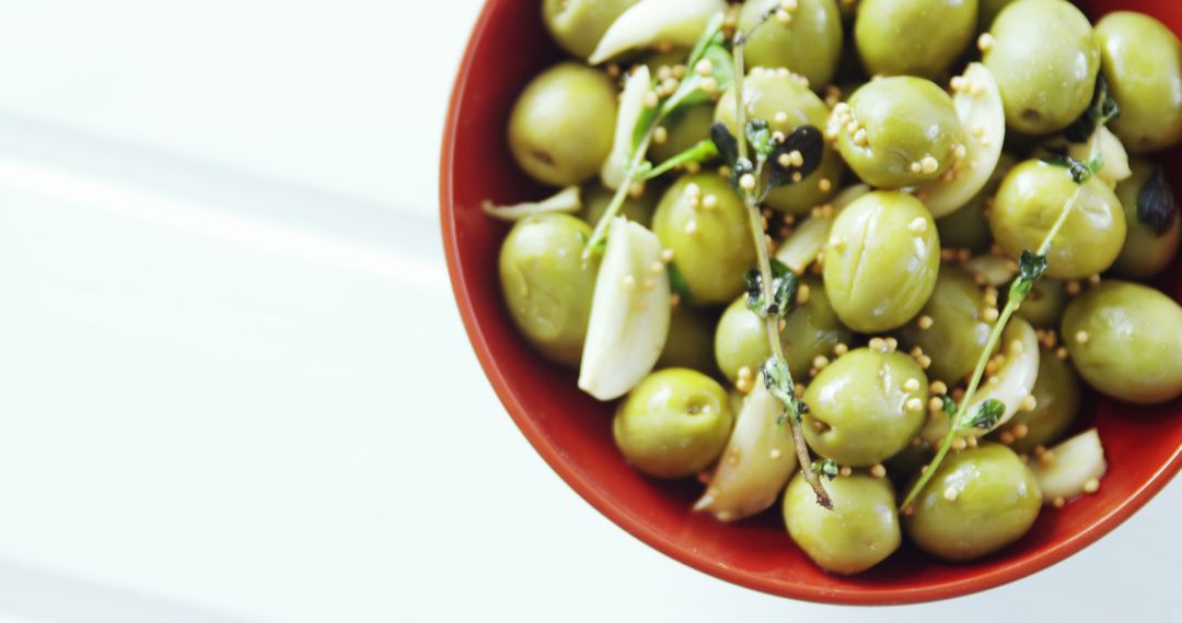 Marinated Green Olives in Red Bowl with Garlic and Herbs - Free Images, Stock Photos and Pictures on Pikwizard.com