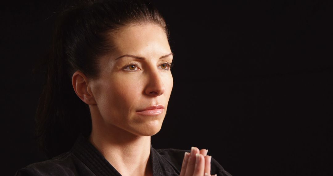 Focused Martial Artist Meditating Against Dark Background - Free Images, Stock Photos and Pictures on Pikwizard.com