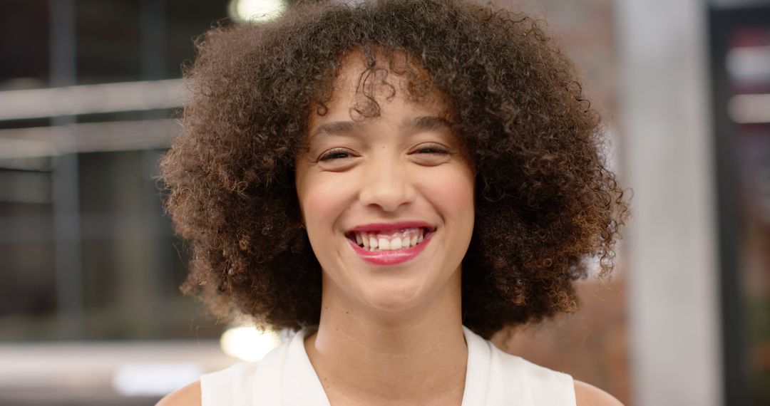 Smiling Woman with Curly Hair in Modern Office Setting - Free Images, Stock Photos and Pictures on Pikwizard.com