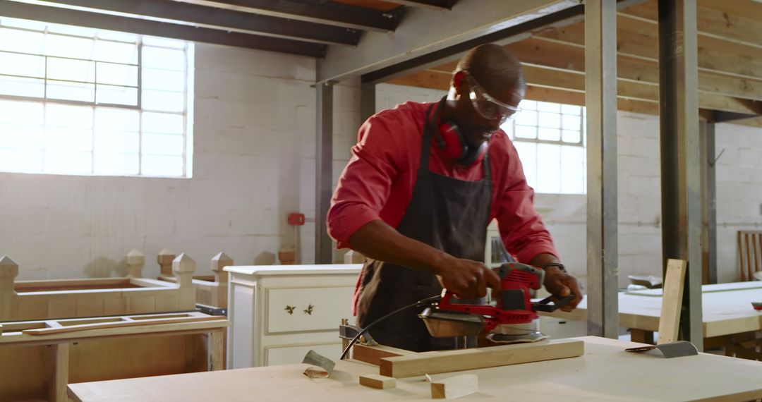 African American Craftsman Using Orbital Sander in Workshop