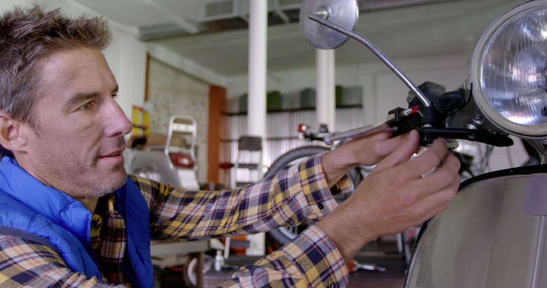 Man Repairing Scooter in Workshop - Free Images, Stock Photos and Pictures on Pikwizard.com