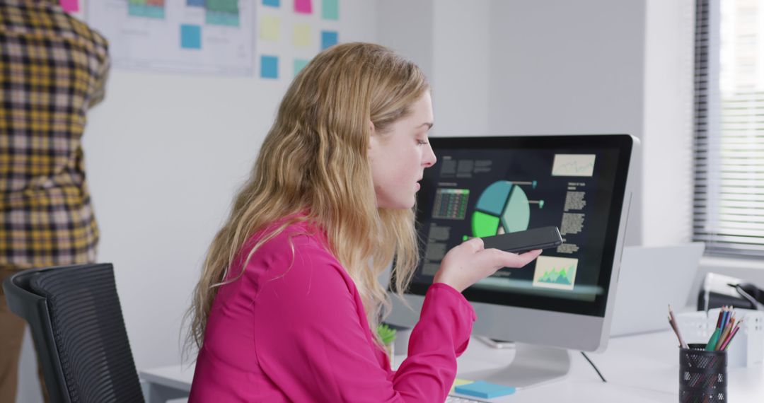 Businesswoman Using Voice Command on Smartphone in Modern Office