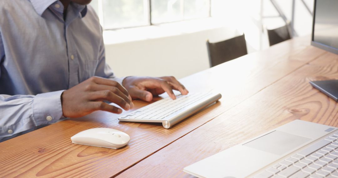 African American Man Typing at Modern Office Workspace