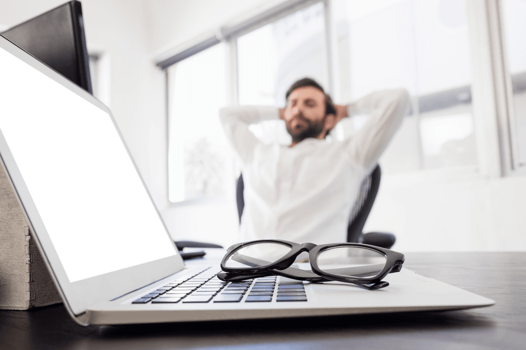 Relaxed Businessman Leaning Back with Transparent Laptop Screen on Desk