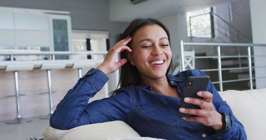 Smiling Young Woman Relaxing Using Smartphone at Home - Free Images, Stock Photos and Pictures on Pikwizard.com