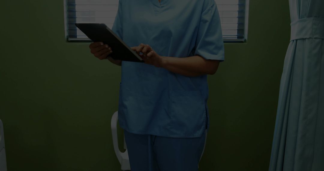 Healthcare Professional in Scrubs Using Tablet for Patient Care