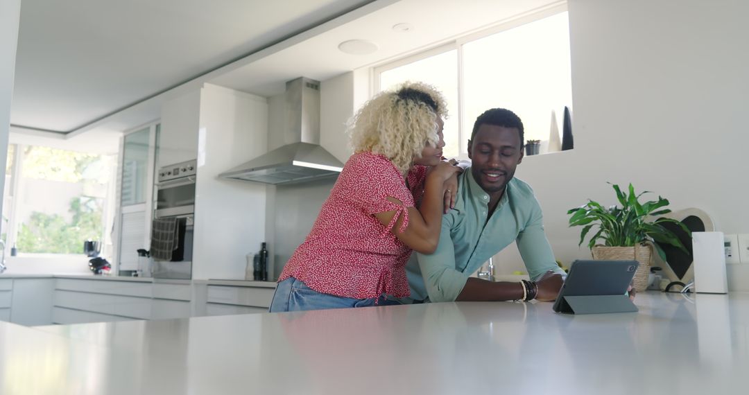 Friends Laughing Together in Kitchen Using Tablet