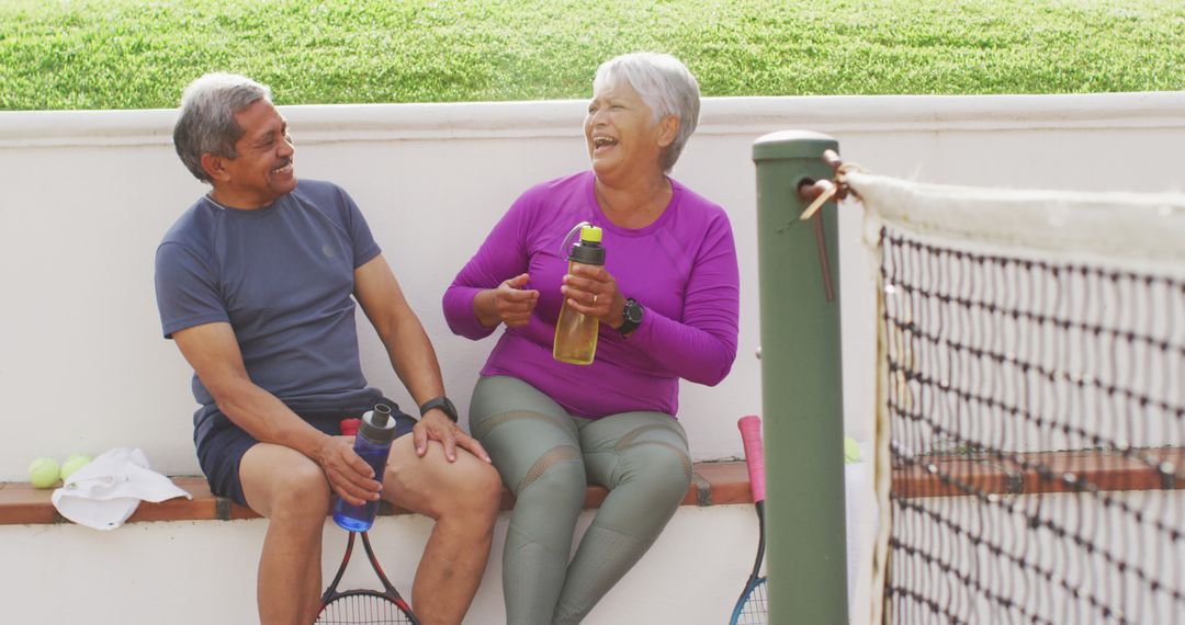 Senior Couple Laughing During Tennis Break - Free Images, Stock Photos and Pictures on Pikwizard.com