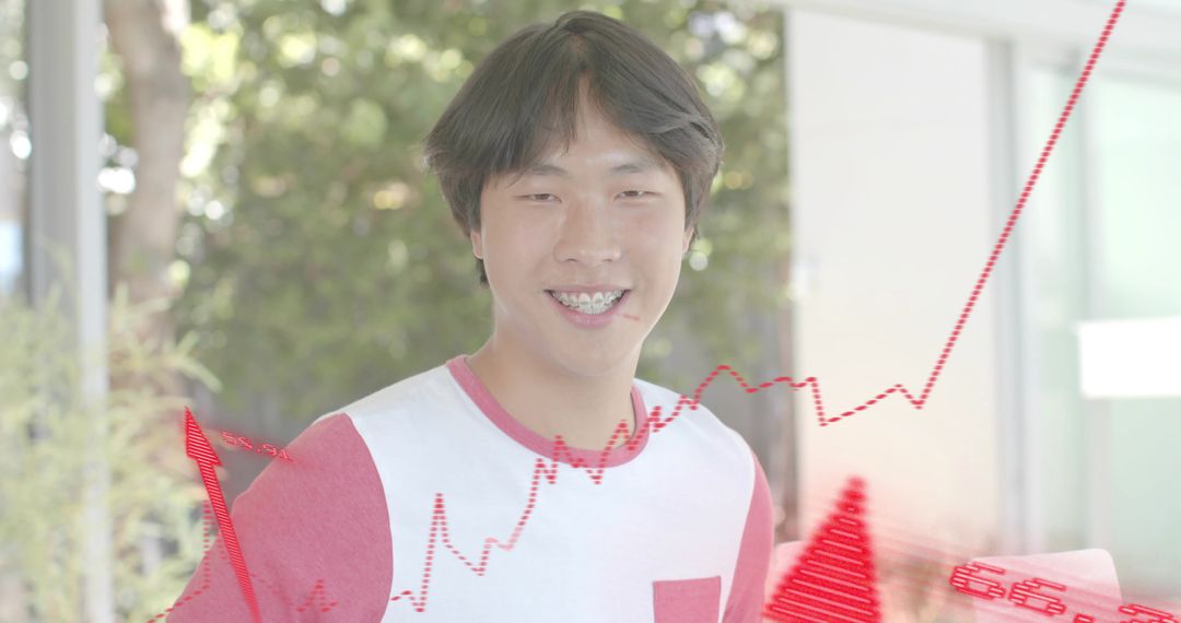 Smiling Asian man with braces wearing white tee posing with red analytics overlays rising chart