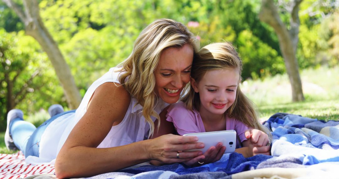 Mother and Daughter Laughing While Using Smartphone Outdoors - Free Images, Stock Photos and Pictures on Pikwizard.com